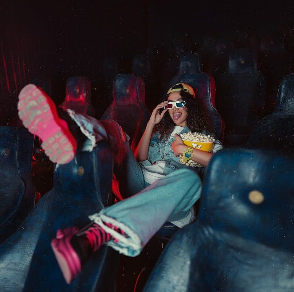 a woman sitting in the middle of a movie theater