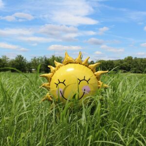 yellow inflatable sun at grass field